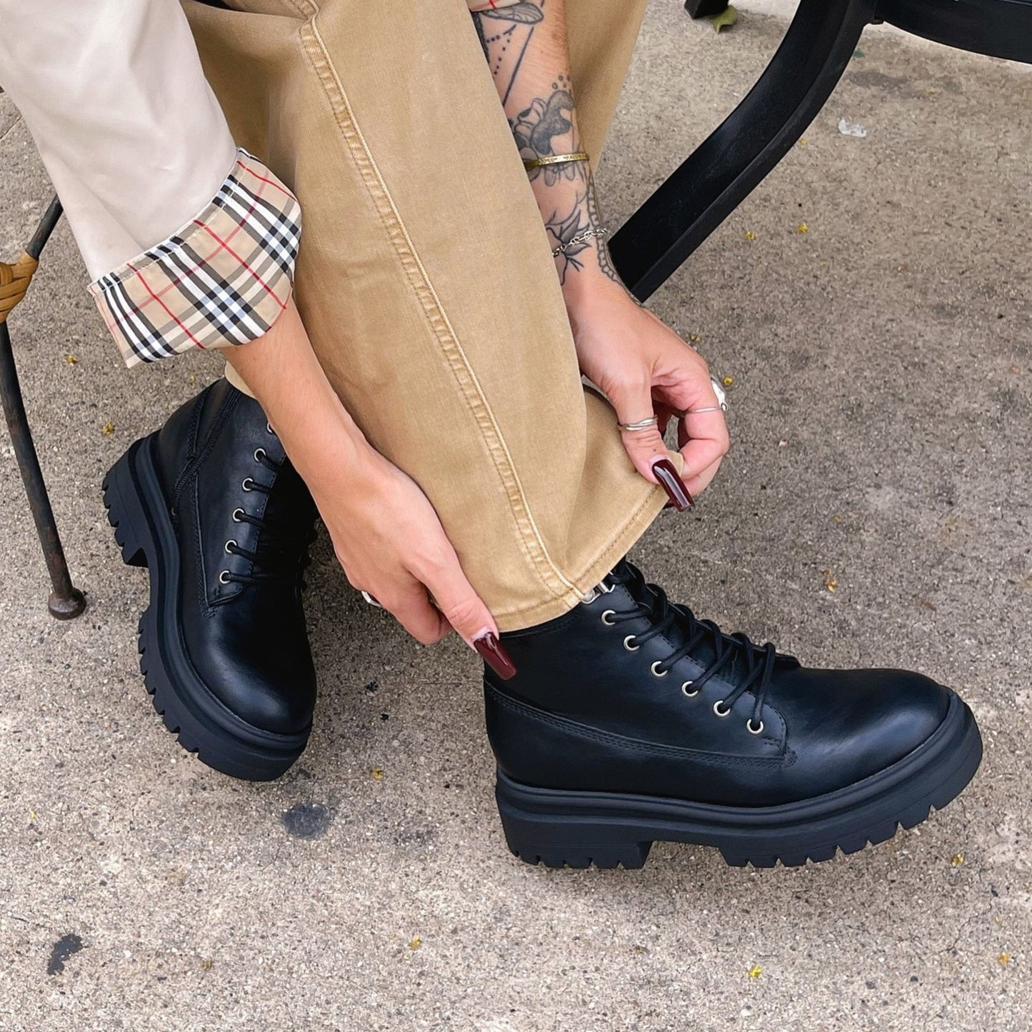 Person wearing black boots on a concrete surface
